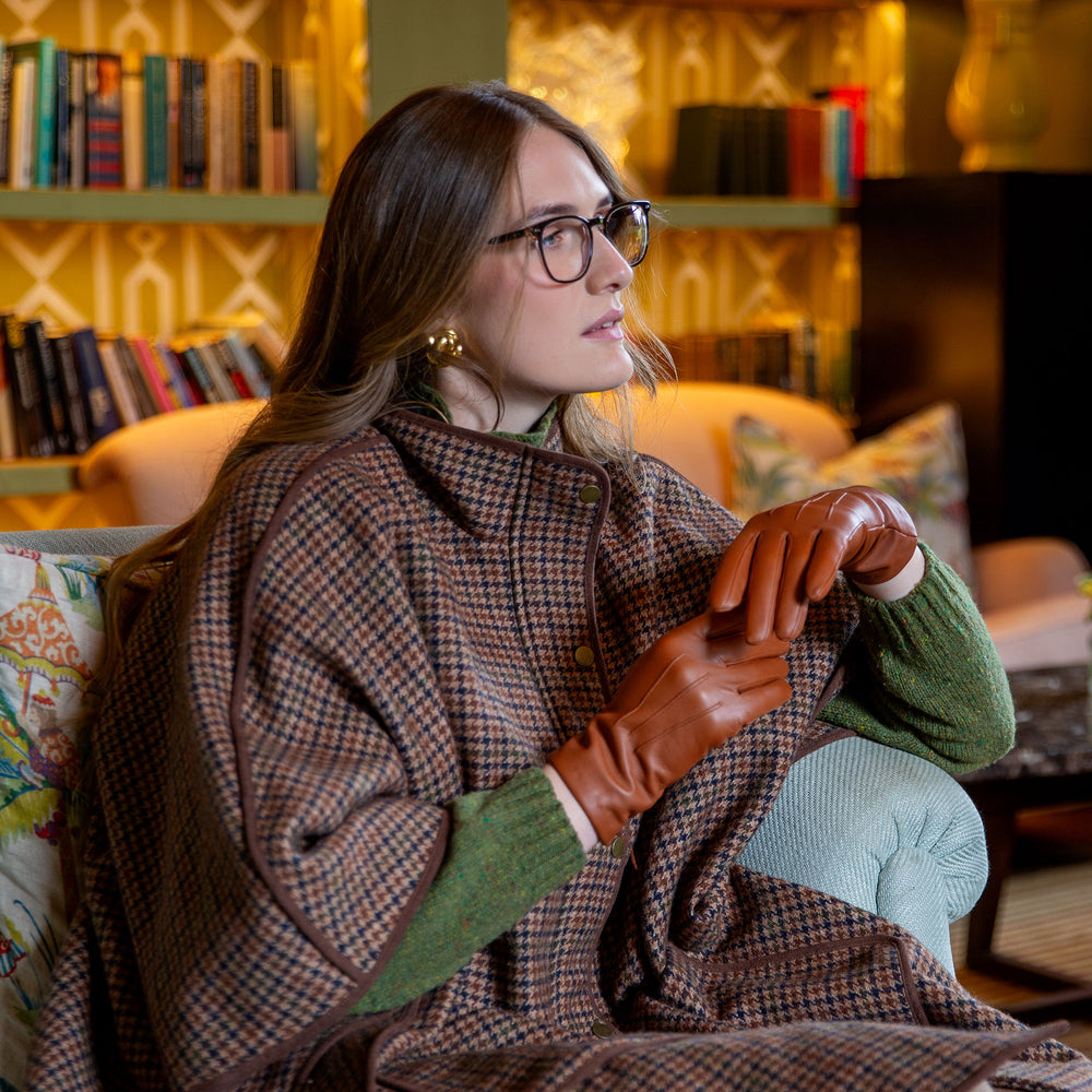 Woman wearing brown leather gloves sat in a library