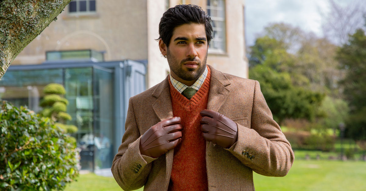 Man wearing english tan cashmere lined leather gloves in the countryside