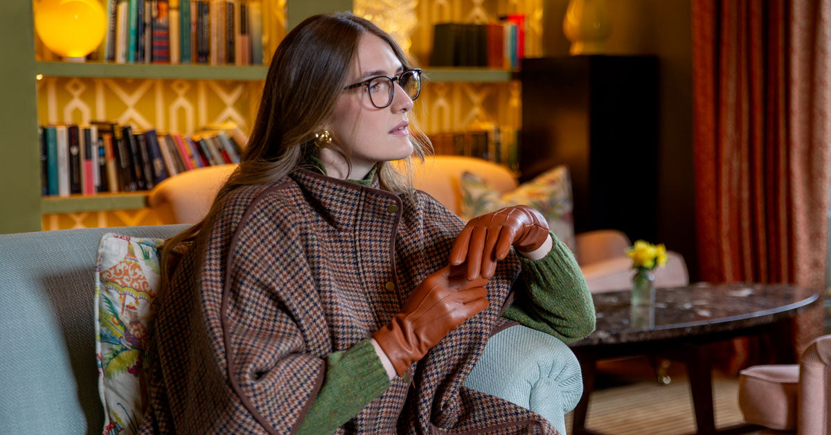 Woman wearing cognac leather cashmere lined gloves in a grand house